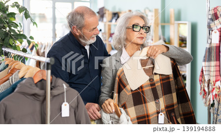 Elderly couple choosing jackets and coats together 139194888