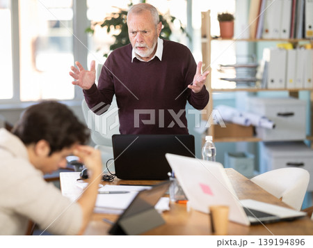 Senior man head of department shouts at guy subordinate who is working with documents Senior man head of department shouts at guy subordinate who is working with documents 139194896