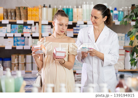 Pregnant woman choosing pills with help of pharmacist Pregnant woman choosing pills with help of pharmacist 139194915