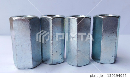 Close-up image of hexagon coupling nut, metal hardware fastener, threaded steel connector for industrial use. 139194923