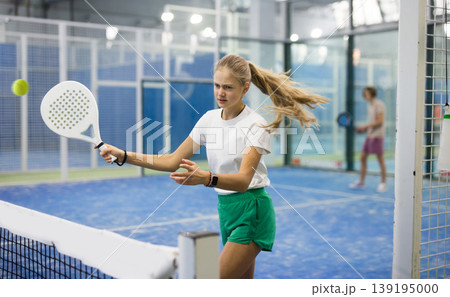 Teenage girl playing padel game on court Teenage girl playing padel game on court 139195000