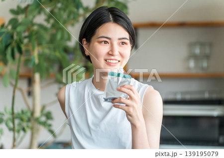 ゼリー飲料,栄養補助ゼリーで栄養補給するスポーツウェア姿の若いアジア人女性 139195079