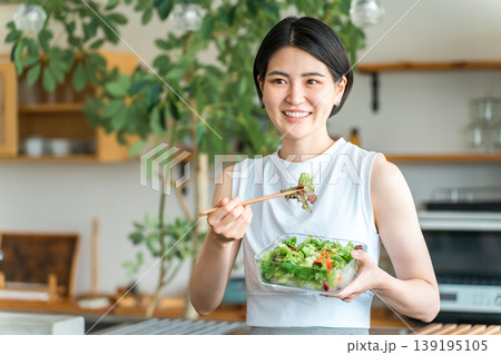 ダイエットメニュを食べるスポーツウェア姿の若い女性 139195105