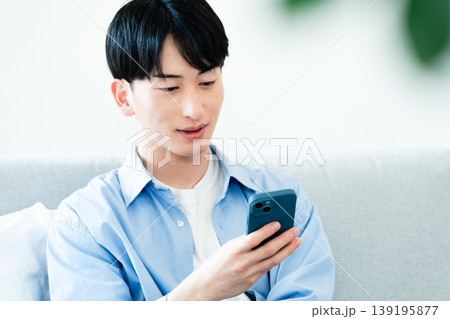 リビングでスマホを使う男性 139195877
