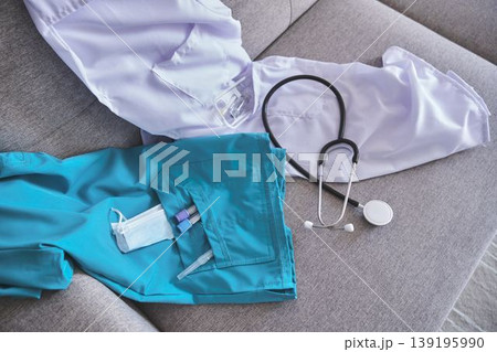 Healthcare worker uniform and equipment laying on a grey couch Healthcare worker uniform and equipment laying on a grey couch 139195990