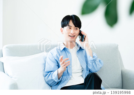 リビングで通話する男性 139195998