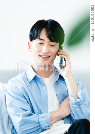リビングで通話する男性 139196003