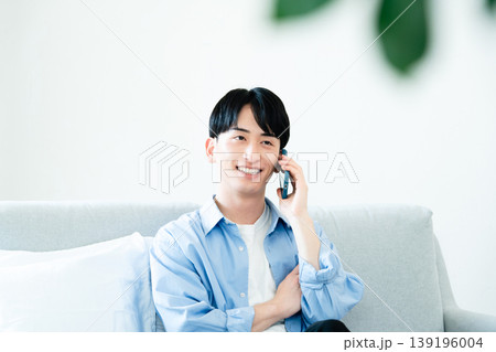 リビングで通話する男性 139196004
