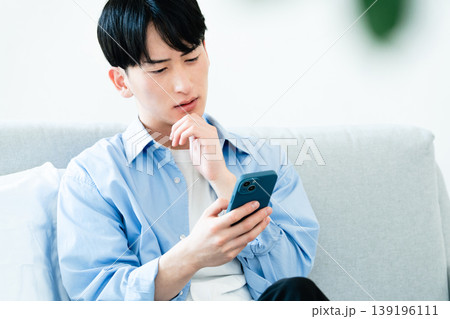 リビングでスマホを使う男性 139196111