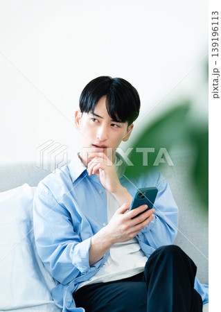リビングでスマホを使う男性 リビングでスマホを使う男性 139196113