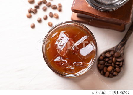 Iced americano coffee in a glass with roasted coffee beans. Popular refreshing summer drink Iced americano coffee in a glass with roasted coffee beans. Popular refreshing summer drink 139196207
