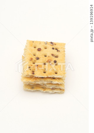 Four pieces of black truffle ham soda biscuits on a white surface. Four pieces of black truffle ham soda biscuits on a white surface. 139196914