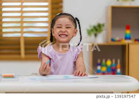 happy preschool child girl drawing and painting with colorful oil pastels on paper happy preschool child girl drawing and painting with colorful oil pastels on paper 139197547