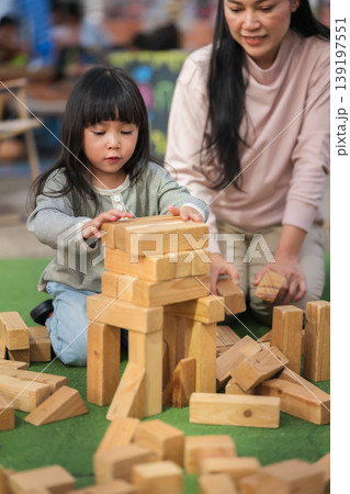 mother and preschool child girl playing with wooden toy block at outdoor mother and preschool child girl playing with wooden toy block at outdoor 139197551