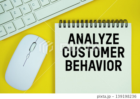 Notepad with the text "Analyze Customer Behavior" and white keyboard and wireless mouse on yellow background Notepad with the text "Analyze Customer Behavior" and white keyboard and wireless mouse on yellow background 139198236