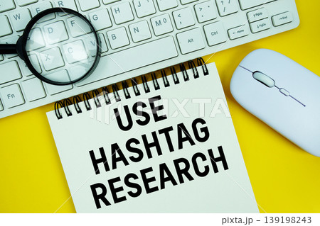 Notepad with the text "Use Hashtag Research" and white keyboard, wireless mouse and magnifying glass on yellow background Notepad with the text "Use Hashtag Research" and white keyboard, wireless mouse and magnifying glass on yellow background 139198243