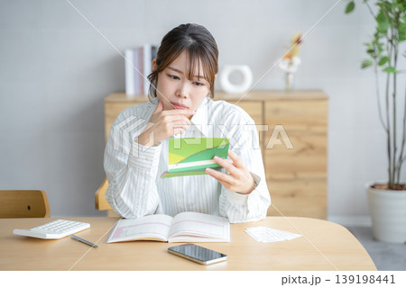 通帳を眺める女性 通帳を眺める女性 139198441