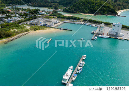 エメラルドグリーンの海に囲まれた沖縄県名護市の汀間漁港を4月に空撮した写真 139198593