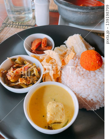 ケララ州特産の米と魚のカレーや副菜が並ぶミールス ケララ州特産の米と魚のカレーや副菜が並ぶミールス 139198709