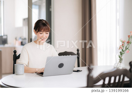 Happy smiling asian woman enjoy remote work and study online for corporate business using laptop computer at cozy home Happy smiling asian woman enjoy remote work and study online for corporate business using laptop computer at cozy home 139199166