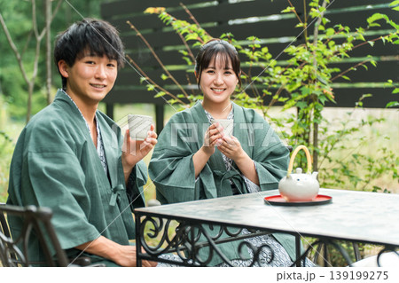 旅先で森林浴をしながらお茶を飲む浴衣姿の夫婦,カップル 旅先で森林浴をしながらお茶を飲む浴衣姿の夫婦,カップル 139199275
