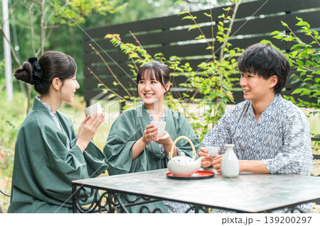 旅館・温泉旅館に旅行,社員旅行に来てテラスでお茶を飲む若い男女（トラベル） 139200297
