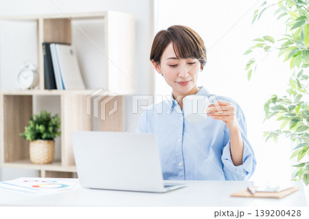 リビングでテレワークをするミドル女性。 リビングでテレワークをするミドル女性。 139200428