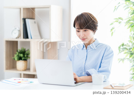 リビングでテレワークをするミドル女性。 リビングでテレワークをするミドル女性。 139200434