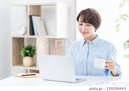 リビングでテレワークをするミドル女性。 リビングでテレワークをするミドル女性。 139200443