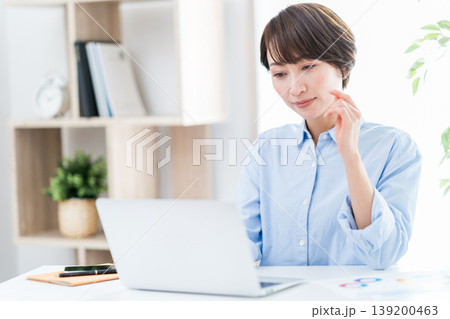 リビングでテレワークをするミドル女性。 リビングでテレワークをするミドル女性。 139200463