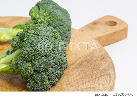 Broccoli lie on a wooden board. 139200476
