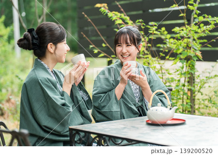 旅先で森林浴をしながらお茶を飲む浴衣姿の若いアジア人女性 139200520