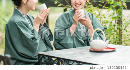旅先で森林浴をしながらお茶を飲む浴衣姿の若いアジア人女性 旅先で森林浴をしながらお茶を飲む浴衣姿の若いアジア人女性 139200521
