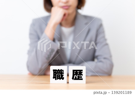職歴のブロックと悩むスーツ姿のミドル女性 139201189