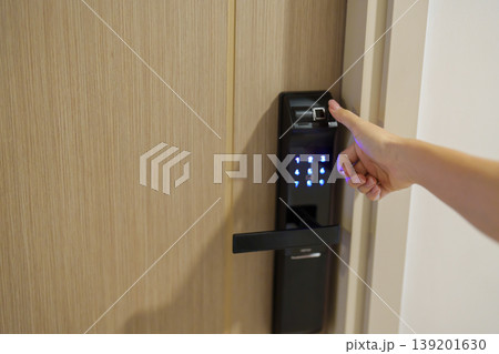 Hand using fingerprint scan for smart digital door lock while open or close the door at home or apartment. NFC Technology, keycard, PIN number, smartphone and contactless lifestyle concepts 139201630