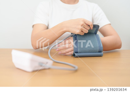 woman checking Blood pressure by Blood pressure monitor with Cuff. Systolic, SYS, Diastolic, DIA, Pulse, Hypertension, Hypotension, Heart rate, Cardiovascular Disease and May World hypertension day 139201634
