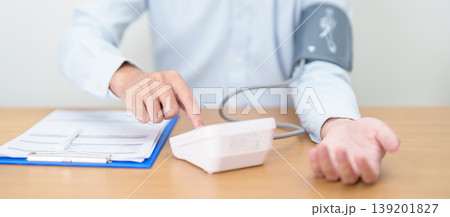 Man checking Blood pressure by Blood pressure monitor with Cuff. Systolic, SYS, Diastolic, DIA, Pulse, Hypertension, Hypotension, Heart rate, Cardiovascular Disease and May World hypertension day 139201827