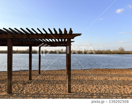 Country beach by the river, wooden canopy against the blue sky of the beach and the river. 139202508
