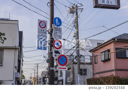 住宅街の電柱に並ぶ道路標識と生活道路の風景 住宅街の電柱に並ぶ道路標識と生活道路の風景 139202588