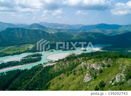 Turquoise Katun River winding through green forested Altai Mountains under a bright sky 139202743