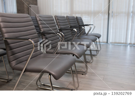 Side perspective of stylish gray conference chairs in modern business meeting room interior Side perspective of stylish gray conference chairs in modern business meeting room interior 139202769