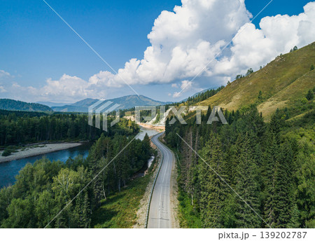 Journey winding through Altai mountains, a road following a bright river under a clear summer sky Journey winding through Altai mountains, a road following a bright river under a clear summer sky 139202787