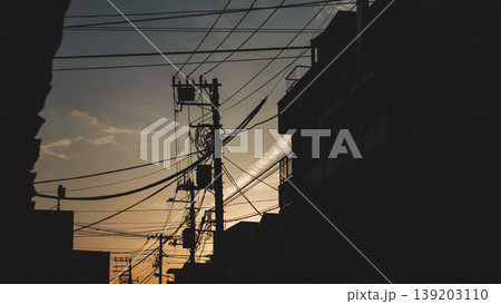 夕暮れの住宅街に浮かぶ電柱と電線のシルエット 139203110