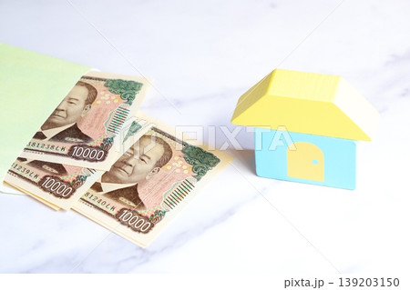 一万円札と家 - 一万円札と家とで、あこがれのマイホームを購入しようとしているイメージ 一万円札と家 - 一万円札と家とで、あこがれのマイホームを購入しようとしているイメージ 139203150