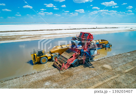 Aerial view captures heavy machinery operates on Lake Baskunchak extracting salt during a clear day mining operation 139203407
