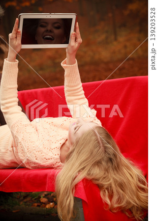 Girl sitting on bench with tablet. Girl sitting on bench with tablet. 139203528