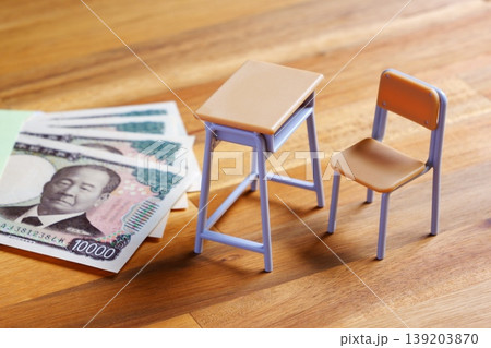 高騰する教育費 - 学校の机と椅子、お金がイメージする、高騰する教育費のイメージ 139203870