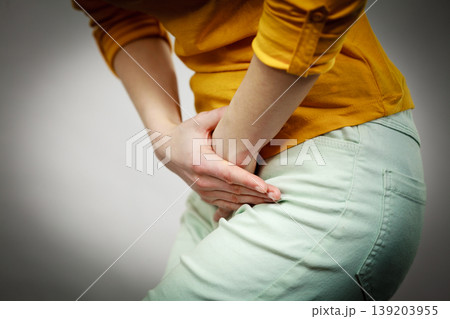 woman with hands holding her crotch woman with hands holding her crotch 139203955