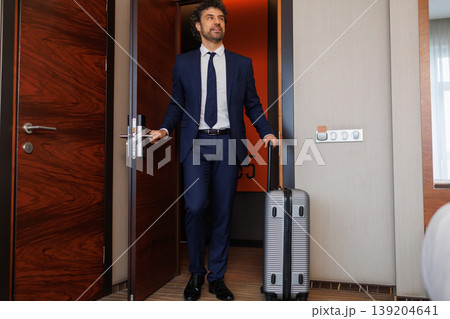 Successful Businessman Arriving Inside Hotel Room With Rolling Suitcase Successful Businessman Arriving Inside Hotel Room With Rolling Suitcase 139204641