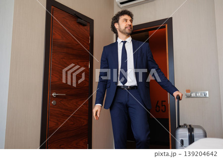 Business Traveler Standing In Hotel Room After Check In With Suitcase Business Traveler Standing In Hotel Room After Check In With Suitcase 139204642